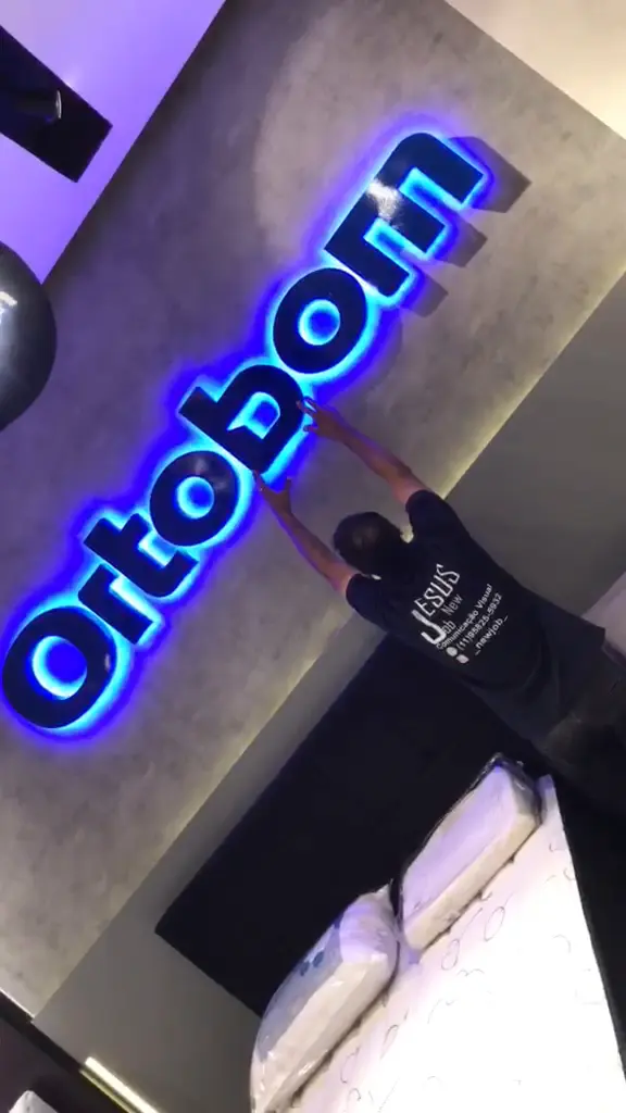 Instalador da Jesus New Job fixando letras caixa azuis com LED da Ortobom