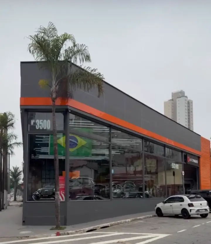 Fachada de showroom automotivo em ACM cinza e laranja