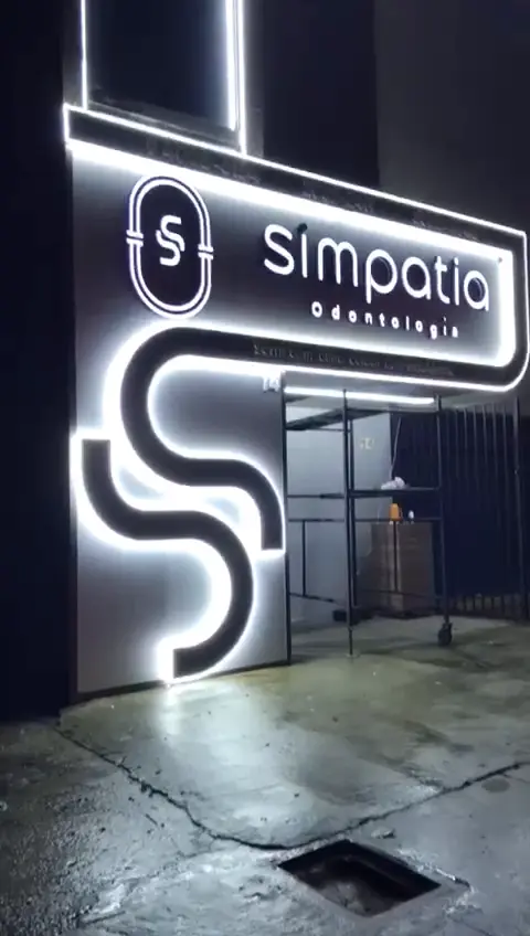 Fachada da Simpatia Odontologia à noite com contornos de LED